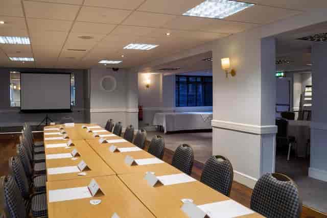 Conference Centre meeting room with long table setup for professional event and presentations.