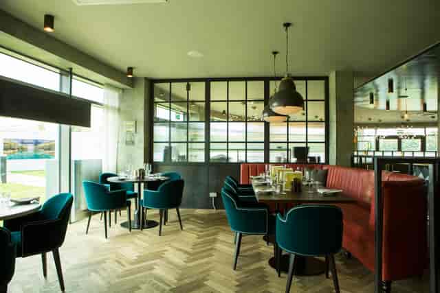 Semi-private dining area with plush teal chairs for intimate meetings and events.