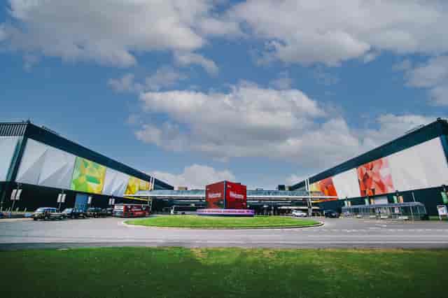 Modern NEC Birmingham auditorium with vibrant murals, perfect for conferences and exhibitions.