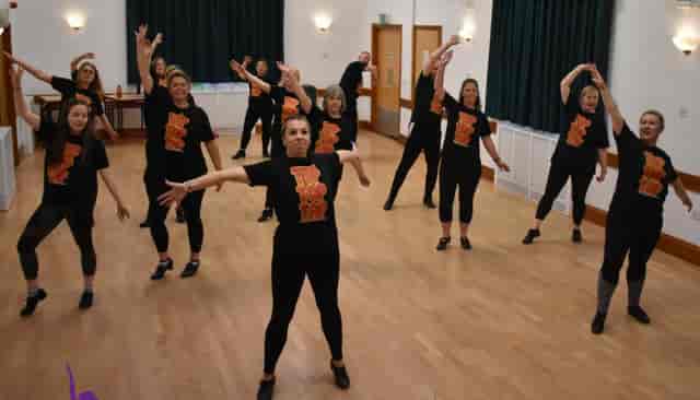 Dynamic dance rehearsal at Chloe May's Dance Academy, showcasing teamwork and energy.