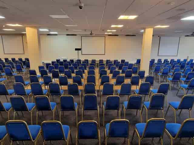 Conference room with blue chairs, ready for a professional event or presentation.