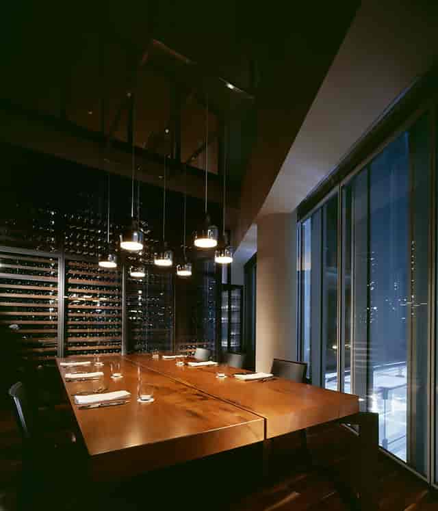 Private dining room with warm wood table, ideal for corporate dinners and exclusive events.