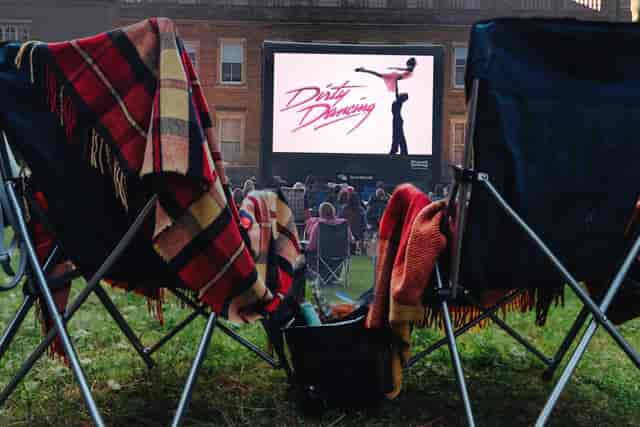 Outdoor cinema setup with cozy seating for a wedding movie night event.