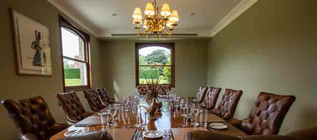 De Port Private Dining Room with elegant wooden table for exclusive meetings and events.