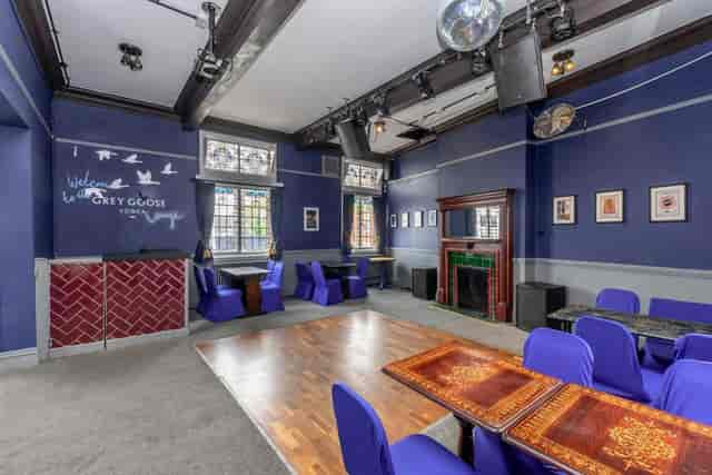 Stylish garden event space with deep blue walls, perfect for gatherings and presentations.