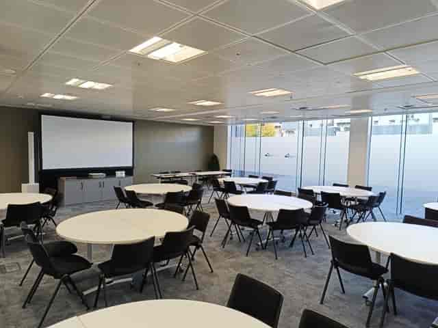 Versatile training room with round tables, ideal for meetings and events at Nishkam Centre.