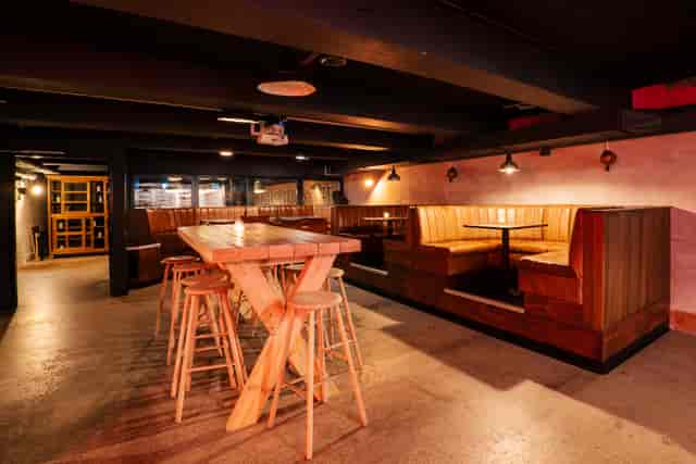 Versatile event space with wooden tables, ideal for networking and casual meetings.