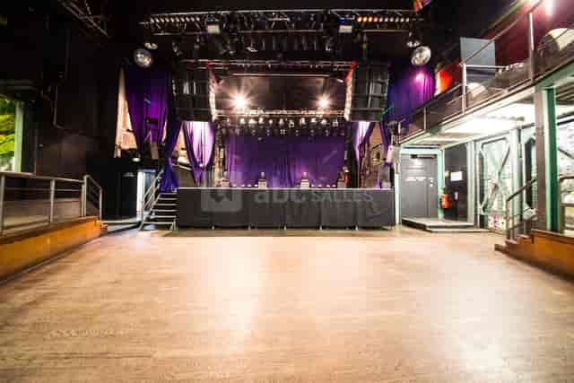 La Chaufferie event space with stage, vibrant purple drapery for concerts and parties.