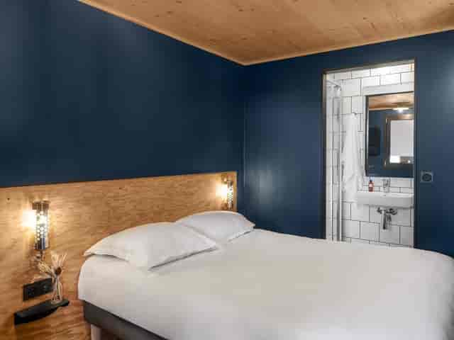 Modern hotel room in Eklo with deep blue walls, perfect for event attendees.