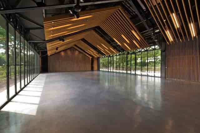 Modern event space with large windows and wooden accents at Les Pavillons des Étangs.