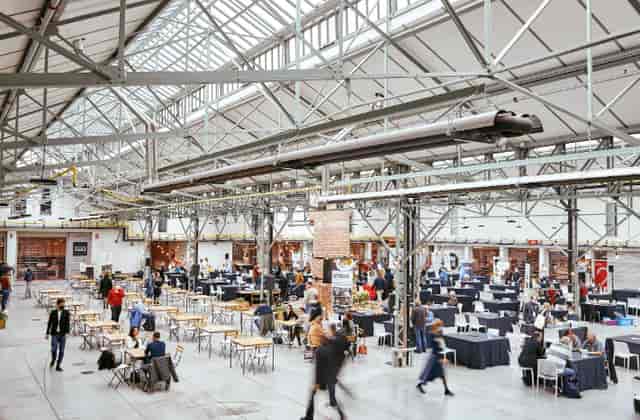 Spacious Be-Here main hall with high ceilings, ideal for networking events and meetings.