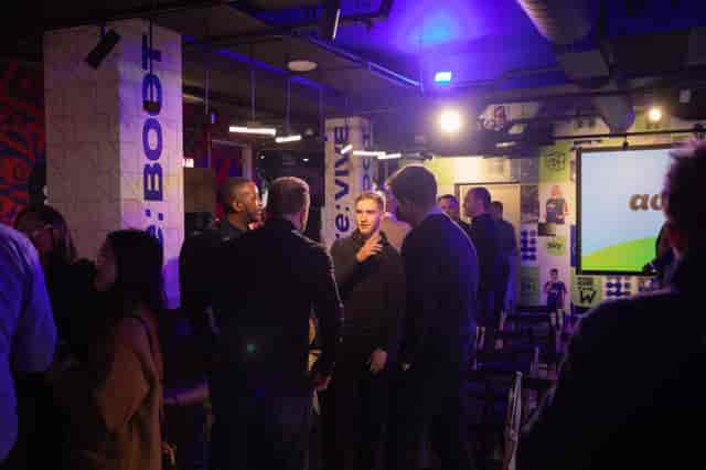 Vibrant networking event at Sky Guild Gaming Centre with dynamic lighting and engaged attendees.