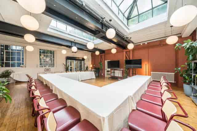 Versatile meeting space at Menier Playhouse with V-shaped table for workshops.