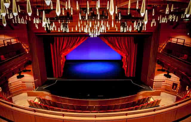 Susie Sainsbury Theatre stage with red curtains, ideal for performances and events.