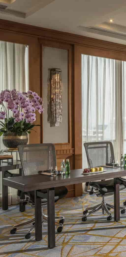 Elegant meeting space at Four Seasons Singapore with orchids, ideal for corporate events.