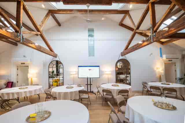 Shoreditch loft venue with round table, screen for workshop, meeting.