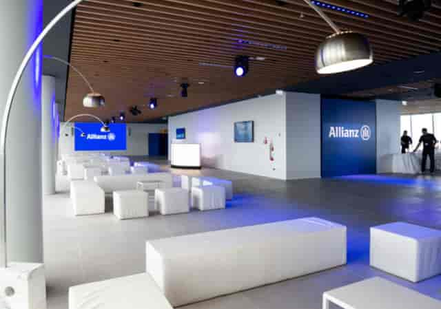 Modern corporate event space in Tower 47 Milano with sleek white seating and branding.
