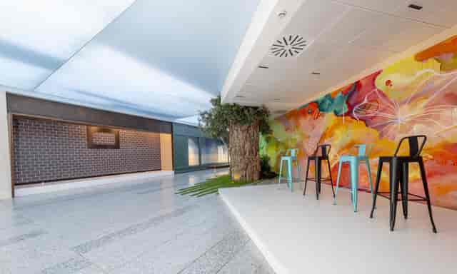 Vibrant Torre Emperador Castellana showroom with colorful mural for workshops and networking.
