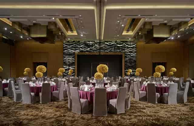 Elegant ballroom setup with floral centerpieces for weddings and corporate events.