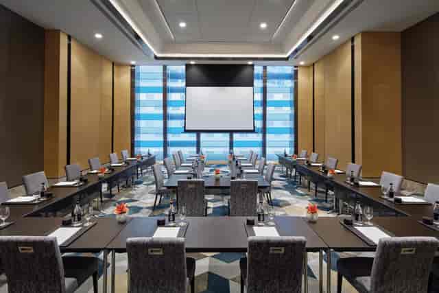 Modern meeting room at Sofitel Singapore, featuring natural light and elegant decor for conferences.
