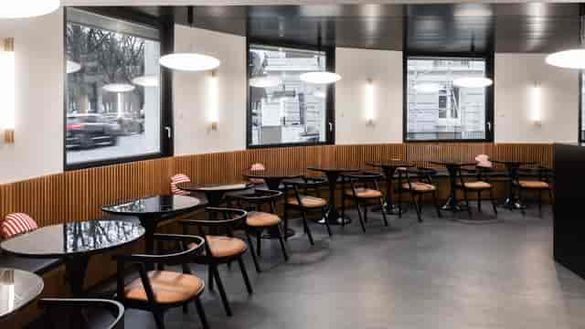 Modern café venue with round tables, ideal for networking events and meetings.