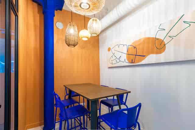 Vibrant Koven Coworking meeting space with orange wall, ideal for creative events.