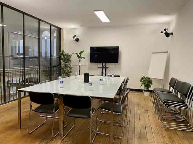 Modern meeting room with glass walls for collaborative events at Koven Coworking.