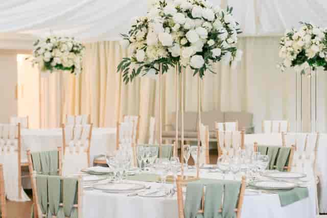 Elegant reception room with round tables, floral centerpieces for weddings and corporate events.