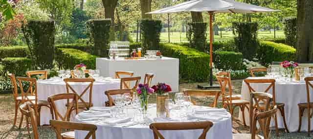Elegant outdoor garden party setup with round tables and lush greenery at Jardin d'hiver.