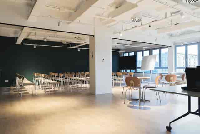 Versatile workshop room with natural light for corporate meetings and presentations.
