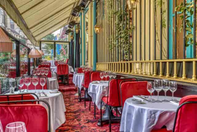Elegant dining lounge at Chez Julien with red chairs, perfect for upscale events.