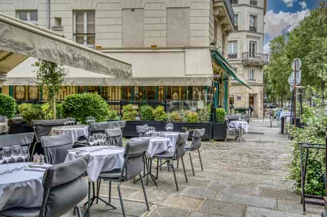 Outdoor dining area at Chez Julien with elegant tables, perfect for networking events.