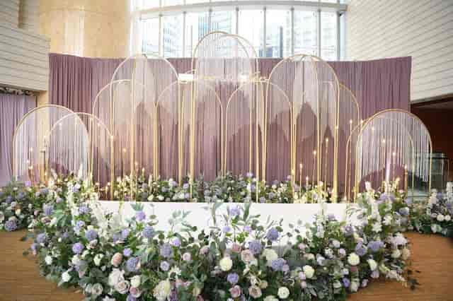 Elegant event stage with gold arches and floral decor at Four Seasons Hotel Hong Kong.