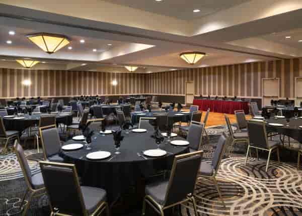 Banquet hall at Regal Airport Hotel with round tables, perfect for conferences and formal dinners.