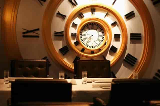 Sophisticated dining space with striking clock for corporate meetings at The Luxe Manor.