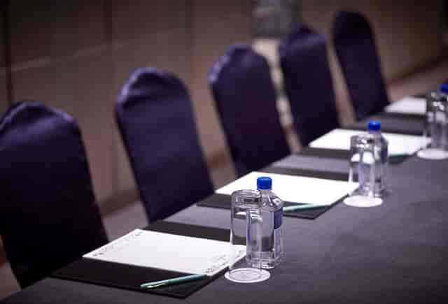 Meeting room setup at Dorsett Wanchai with sleek table, notepads, and elegant decor.