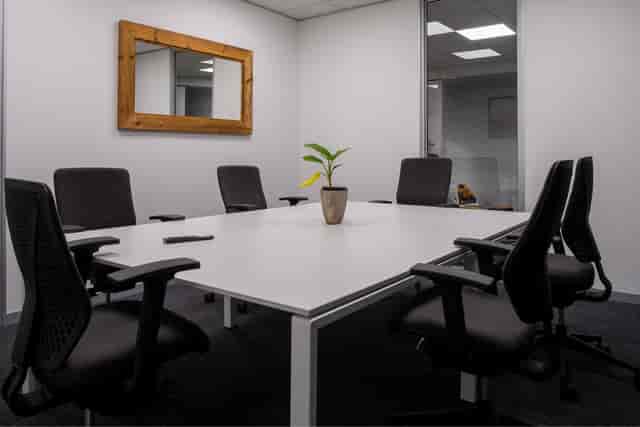 Modern boardroom with white table and ergonomic chairs for collaborative meetings.