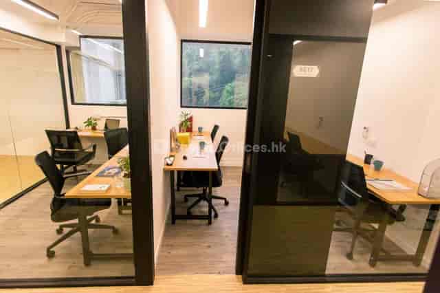 Modern coworking space in HK Works with glass-walled rooms for meetings and collaboration.