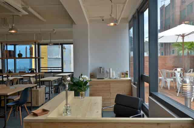 Modern meeting space in The Hive Wan Chai with wooden furniture, ideal for networking events.