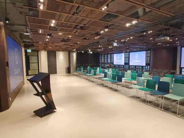 Modern event space with sleek podium and colorful chairs for presentations.