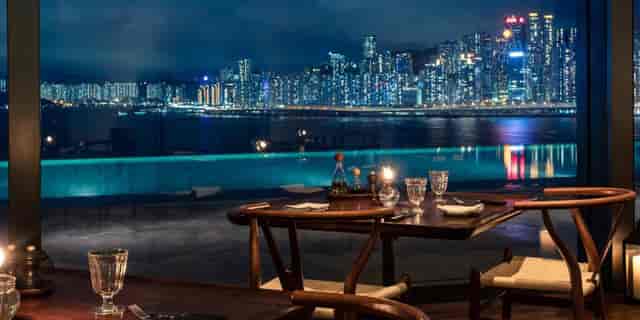 Elegant waterfront dining area with city skyline, perfect for upscale events and receptions.