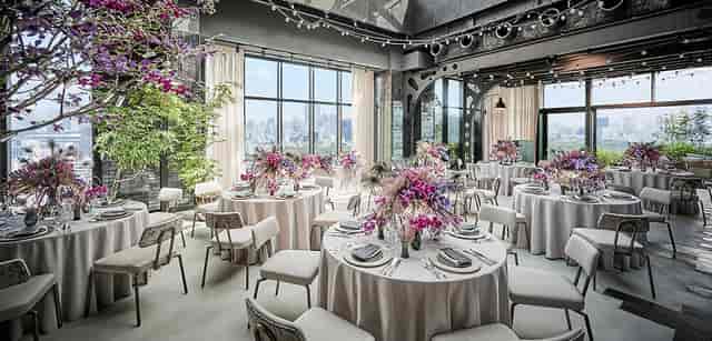 Elegant event space in Kimpton Shinjuku Tokyo with floral centerpieces and city views.