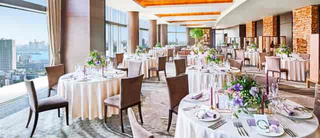 Elegant wedding venue at InterContinental Tokyo Bay with floral centerpieces and natural light.
