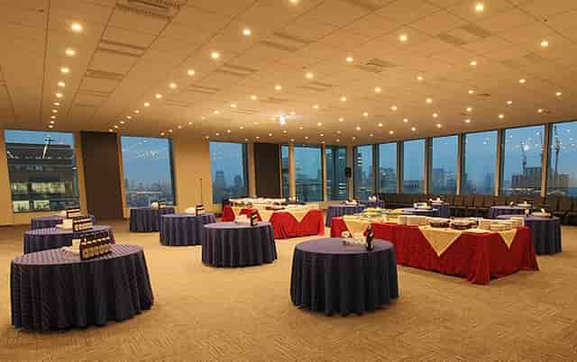 Spacious banquet hall with blue tablecloths, ideal for networking events and receptions.