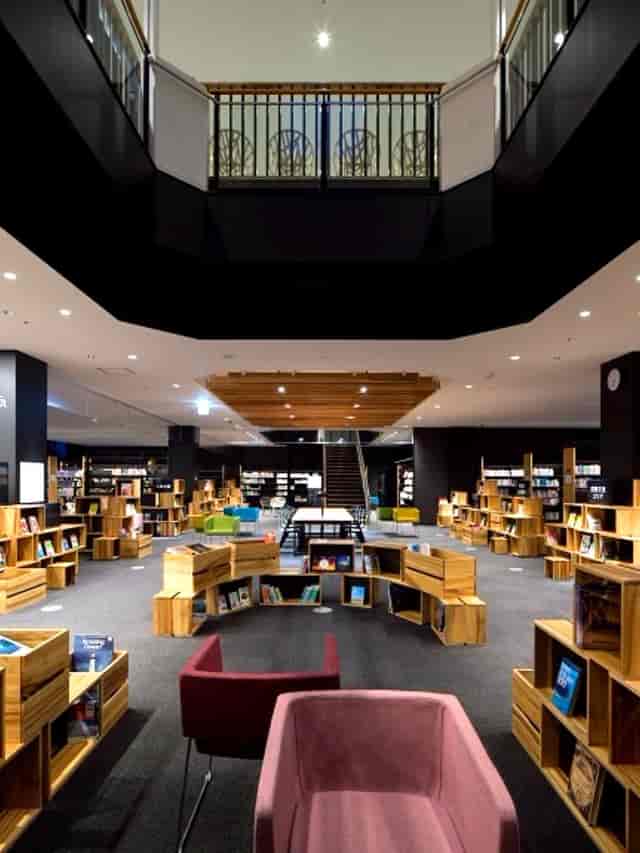 Modern Kōdōkan library with circular wooden bookshelves for workshops and meetings.