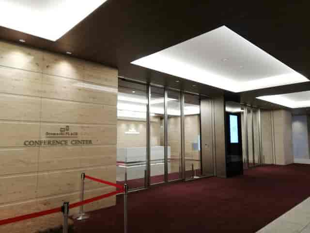 Modern conference hall entrance with polished stone and red carpet for professional events.