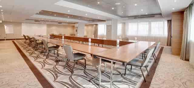 Modern Hilton Milan ballroom with elegant table, ideal for corporate meetings and workshops.