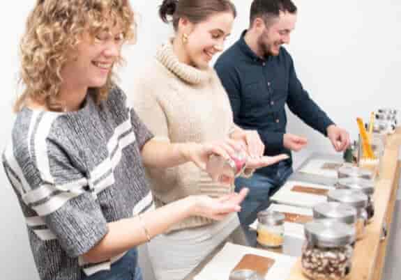 Hands-on chocolate workshop with smiling participants in a creative team-building setting.