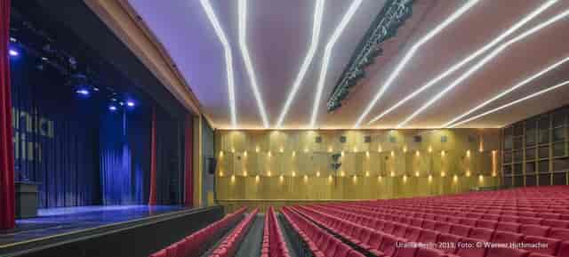 Modern auditorium in Keplersaal, Urania Berlin with tiered red seating for conferences.