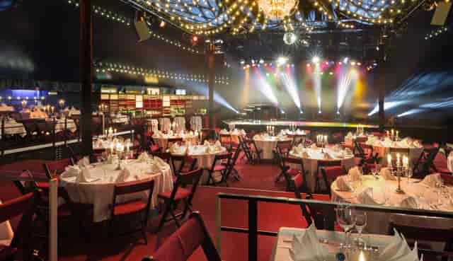 Elegant gala event space with round tables and candle centerpieces at TIPI AM KANZLERAMT.